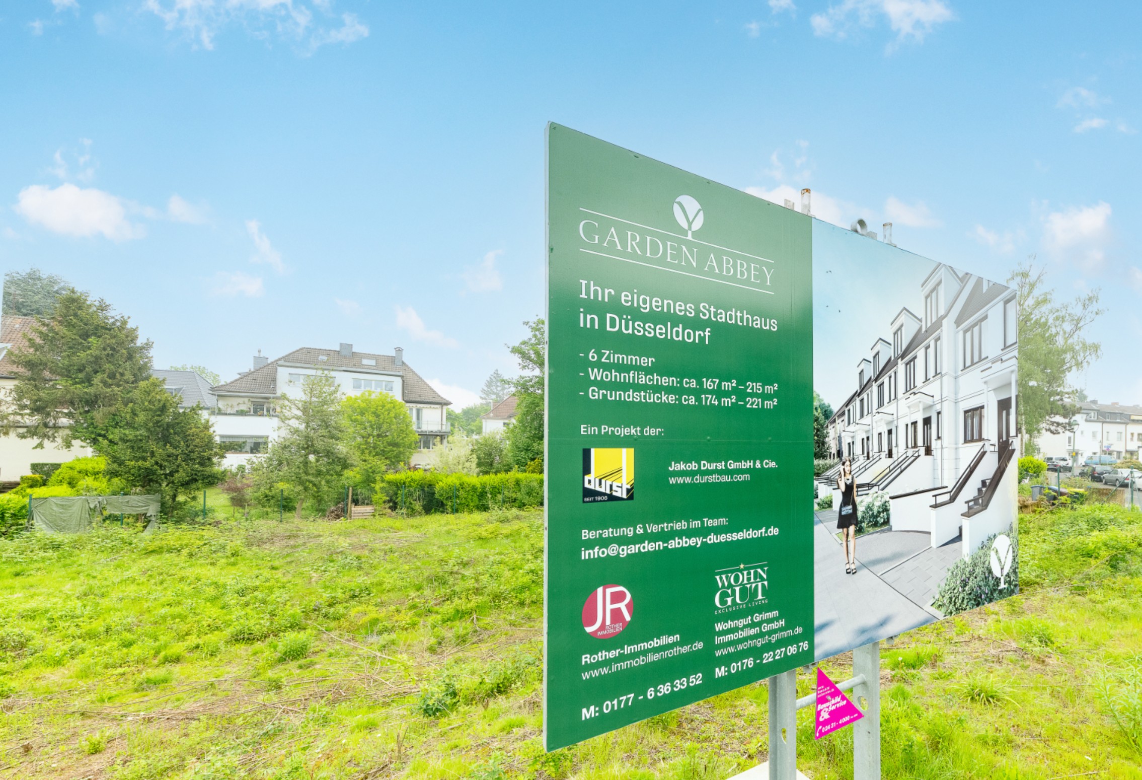 "Großes Bauschild für ""GARDEN ABBEY"" in Düsseldorf, bewirbt Stadthäuser mit Details zu Zimmern, Wohn- und Grundstücksflächen."